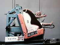 試験用シートに子どものダミー人形を乗せ前面衝突を再現。チャイルドシートとダミー人形へのダメージを測定し安全性を計測する