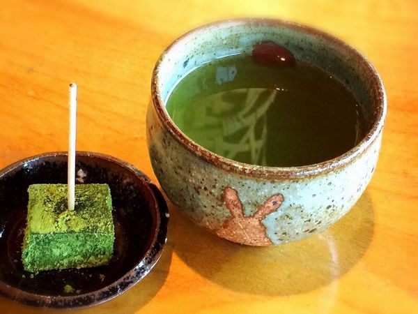 ▲食後に供されるデザートと日本茶。日本茶が入っている湯飲み茶碗は陶芸家さんの作で、手前のウサギがお客自身を表し、お茶が相模湾、そしてその向こうにある赤い丸が「相模湾に沈む夕日」を表している