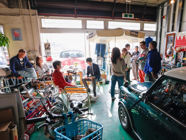 ▲お店にふらっと立ち寄ったお客さんに呼びとめられる酒井社長（右から2番目）。ちなみにカメラの後ろ側やお店の外にもお客さんがいるんです