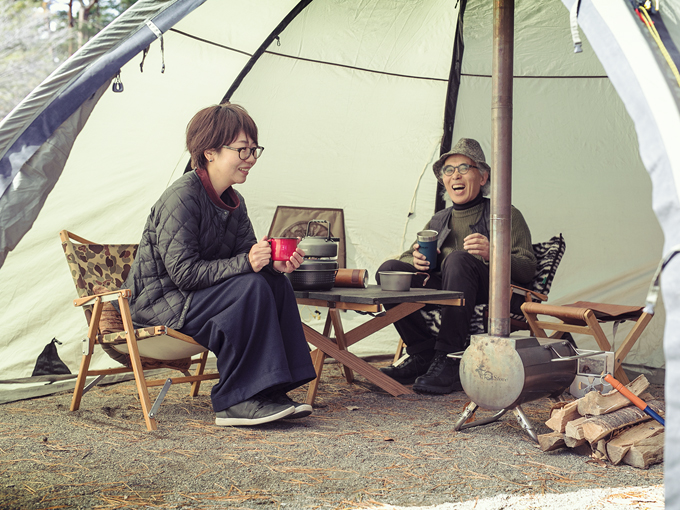 ▲まきストーブを設置したテントでくつろぐ後藤さんと渡辺さん。若さを保つ秘訣はオートキャンプなり！